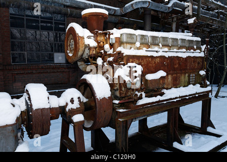 L'homme de l'âge, le moteur diesel 8 cylindres, à l'aide du cric, neige, exposition dans le jardin paysager Duisburg-Nord, aciérie désaffectée Banque D'Images