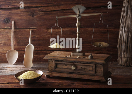 Pesage balances antiques de grains de Millet (Panicum miliaceum) sur une surface en bois Banque D'Images