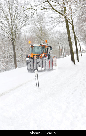 Trecker déblayer la neige sur une route de campagne Banque D'Images