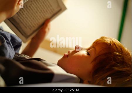 Enfant, boy reading in bed Banque D'Images