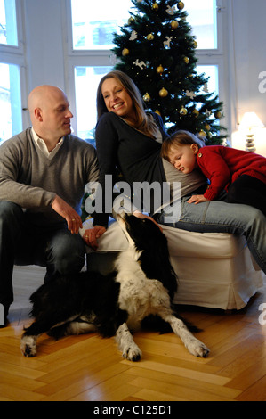 Famille heureuse avec sa fille, père, mère enceinte et de chien, arbre de Noël Banque D'Images