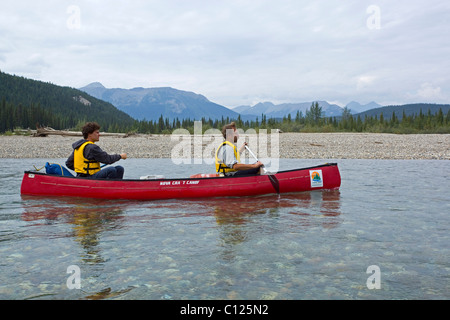 Deux hommes dans un canoë, kayac Upper Liard River, claire, l'eau peu profonde, derrière les montagnes Pelly, Territoire du Yukon, Canada Banque D'Images