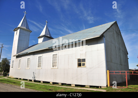 Ciel bleu Vue de côté de l'église en bois de métal de l'argent de San Antonio de chacao, debout sur des socles en bois, l'île de Chiloé, Chili Banque D'Images