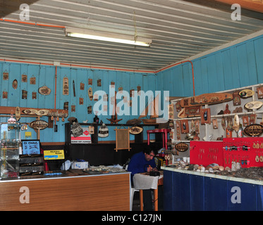 Vue intérieure d'un artisanat souvenirs artesania-shop, avec un homme travaillant sur des objets d'artisanat, Plaza Martin Ruiz, Chacao, Chiloé, Chili Banque D'Images