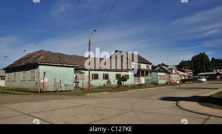 Vue du ciel bleu d'une rangée de maisons en bois, avec des murs de galets vert brun, bardeaux de toiture, Plaza Martin Ruiz, Chacao, Chiloé, Chili Banque D'Images