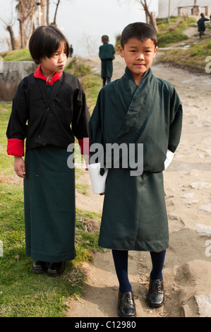 Jeunes bhoutanais garçon et fille sur le chemin de la première journée d'école en milieu rural Bhoutan vêtus de l'uniforme scolaire Banque D'Images