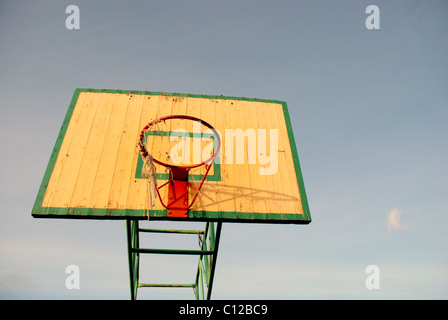 Avec une vieille carte de basket-ball Basket-ball en lambeaux sur le net hoop Banque D'Images