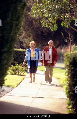 Couple retraités marche dans un quartier de San Marino, Californie Banque D'Images