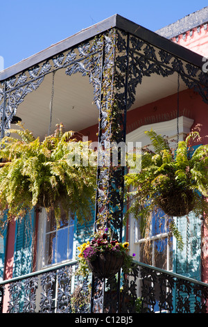 Du balcon en fer forgé orné avec les semoirs suspendus dans le quartier français de La Nouvelle-Orléans, Louisiane Banque D'Images