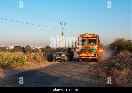 Camion transport Inde voyageant le long d'une route d'être dépassée par un véhicule 4x4 dans la campagne indienne. L'Andhra Pradesh, Inde Banque D'Images