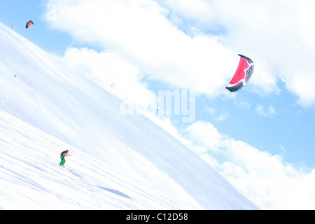 Snowkite équitation dans les montagnes de l'Utah. Voile de couleur jaune vif et bleu ciel au-dessus des montagnes couvertes de neige. Haut dans les montagnes. Banque D'Images