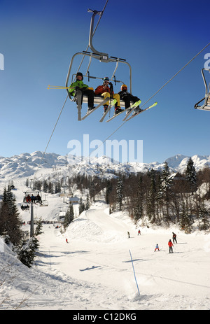 Skieurs sur un télésiège au centre de ski de Vogel dans le parc national du Triglav de Slovénie Banque D'Images