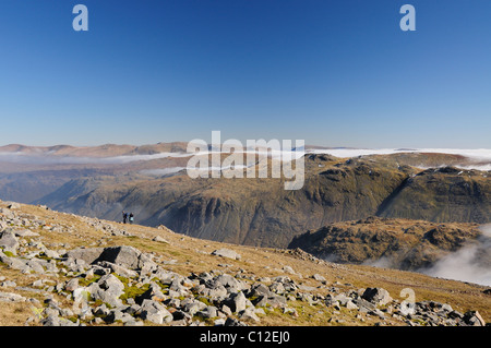 Les promeneurs sur Grand Gable surplombant Seathwaite tomba et Glaramara sur une journée de printemps ensoleillée dans le Lake District Banque D'Images