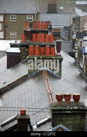 Toit en ardoise humide et pots de cheminée sur terrasse maisons Banque D'Images