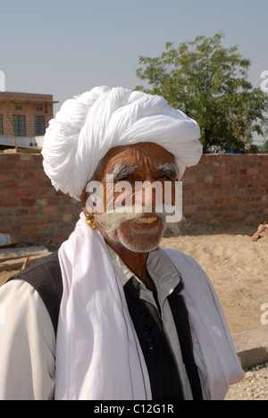 Portrait of smiling Rajasthani homme heureux en turban blanc au travail Banque D'Images