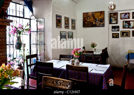 Belle et bien éclairé, intérieur rustique de style maison d'Oaxacan restaurant avec des photos de famille sur le mur dans la ville d'Oaxaca au Mexique Banque D'Images