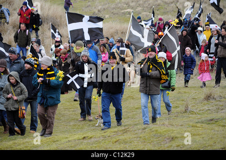 Cornouaillais mars à travers les dunes à Rolvenden, Cornwall, UK, au cours de l'assemblée annuelle de la fête de St Pirans. Banque D'Images