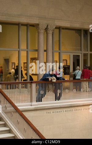 Les gens s'appuient sur la rampe de l'administration de la femme Grand escalier au Chicago Art Institute. Banque D'Images