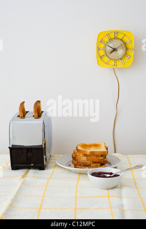 Toast au grille-pain sur la table du petit déjeuner Banque D'Images