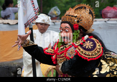 Le port d'un masque topeng interprète lors d'une performance à un temple cérémonie à Padang Bai Bali Indonésie Banque D'Images