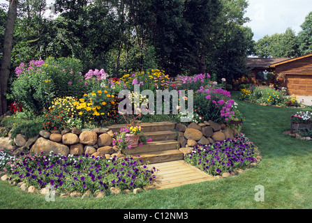 Lit DE JARDIN POSÉE JOURNAL AMÉRICAIN HOME comprend les pétunias, GIANT TAGÈTES, black-eyed, SUSANS CLEOME ET ROSES. L'été. Banque D'Images