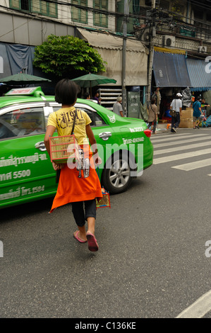 Jeune fille vendre des oiseaux d'être libérés pour faire du mérite, Chinatown , rues de Bangkok, Thaïlande Banque D'Images