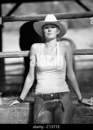 USA, Colorado, Portrait de cowgirl sitting by fence Banque D'Images