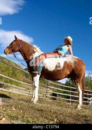 USA, Colorado, cowgirl relaxant avec cheval ranch Banque D'Images