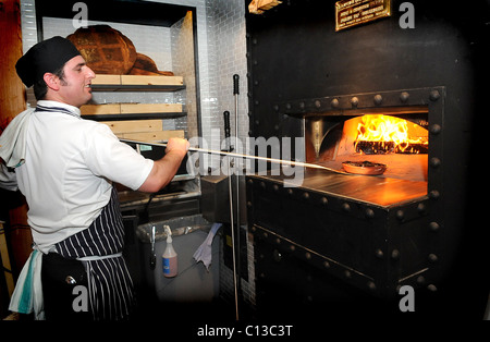 Un chef met un plat dans le four à bois dans Jamie's Italian dans la région de Brighton, la chaîne est administré par le célèbre chef Jamie Oliver Banque D'Images