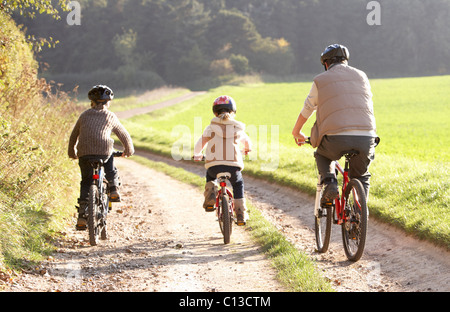 Jeune père avec les enfants faire du vélo dans la région de park Banque D'Images