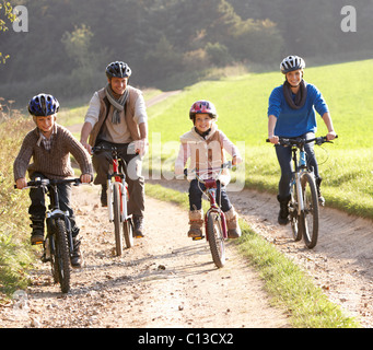 Les jeunes parents avec enfants faire du vélo dans la région de park Banque D'Images