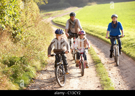 Les jeunes parents avec enfants faire du vélo dans la région de park Banque D'Images