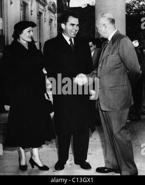 1954 Présidence des États-Unis. Le président américain Dwight Eisenhower accueille le Vice-président (et futur président des Etats-Unis) Richard Nixon et la deuxième Dame (et future première dame) Patricia Nixon sur le portique nord de la Maison Blanche à leur retour d'une visite éclair à l'Asie et le Moyen-Orient, Janvier, 1954. Banque D'Images