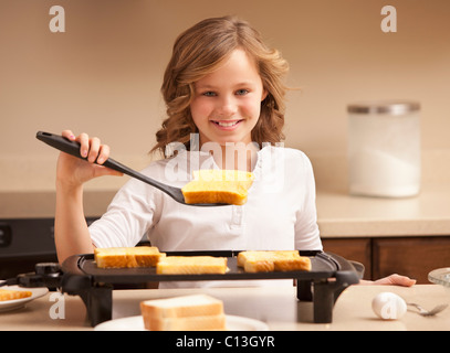 USA, Utah, Léhi, Portrait of Girl (10-11) la préparation du pain grillé dans la cuisine Banque D'Images