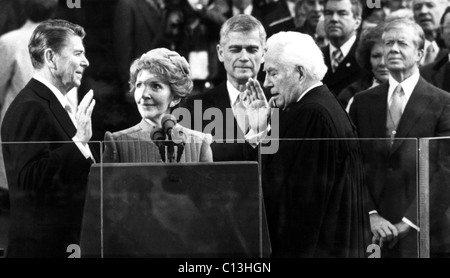 Ronald Reagan a prêté serment en tant que président par le juge en chef Warren Burger comme Nancy Reagan, le sénateur Mark Hatfield, le président Jimmy Carter, regardez sur 1/20/81 Banque D'Images