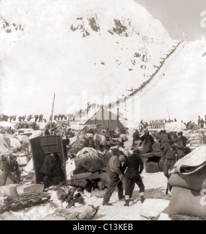 Long ruban de mineurs liés pour les champs aurifères du Klondike, grimpant sur le col Chilkoot Pass, en 1898. Banque D'Images