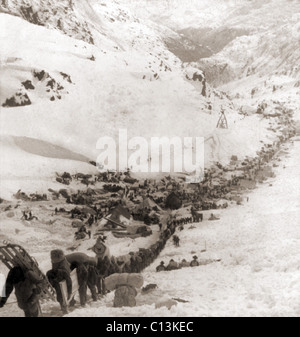 Long ruban de mineurs liés pour les champs aurifères du Klondike, grimpant sur le col Chilkoot Pass, en 1898. Banque D'Images