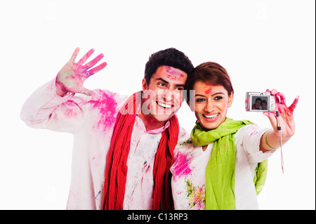 Les amis de prendre une photo d'eux-mêmes avec un appareil photo sur Holi Banque D'Images