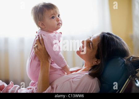 USA, California, Berkeley, Mother holding baby girl (6-11mois) sur canapé Banque D'Images