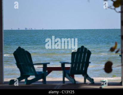 Deux chaises Adirondack peinte en bleu à l'ombre avec vue sur la baie de Tampa. Banque D'Images