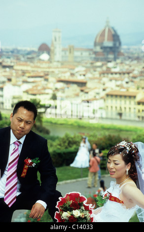 Couple de jeunes mariés ayant des photos prises sur la Piazzale Michelangelo, Florence, Italie Banque D'Images
