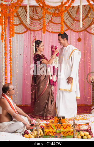 Mariée à un époux garland mise au cours de la cérémonie de mariage indien du Sud Banque D'Images