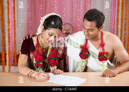 Couple de signer un certificat de mariage Banque D'Images