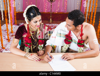 Couple de signer un certificat de mariage Banque D'Images