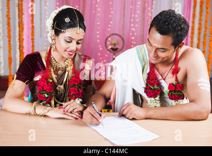 Couple de signer un certificat de mariage Banque D'Images