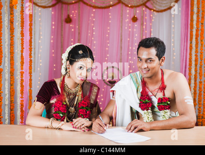 Couple de signer un certificat de mariage Banque D'Images