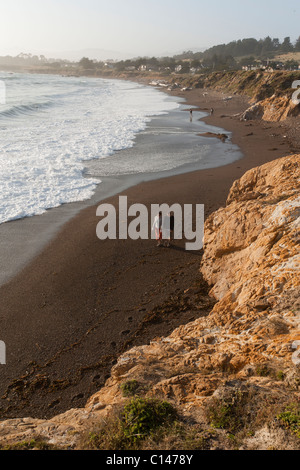 Couple en train de marcher sur une plage de sable avec vue sur océan Pacifique à Moonstone Beach dans la région de Cambria, Californie. Banque D'Images