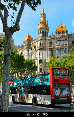 Bus de tourisme en face d'un bâtiments à Paseo de Gracia, juste à côté de l'angle nord-est de la Plaza Catalan à Barcelone, Espagne. Banque D'Images