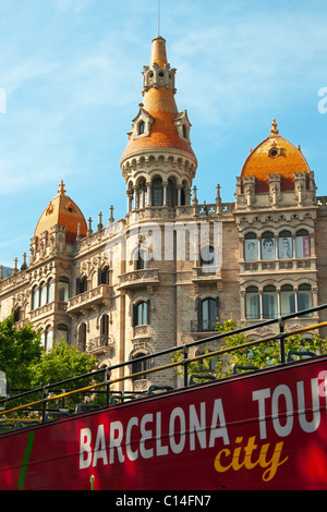 Bus de tourisme en face d'un bâtiments à Paseo de Gracia, juste à côté de l'angle nord-est de la Plaza Catalan à Barcelone, Espagne. Banque D'Images