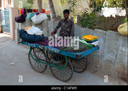 Blanchisserie rue traditionnelle indienne (homme) dhobi planche sur un chariot de lavage à Puttaparthi, Andhra Pradesh, Inde Banque D'Images